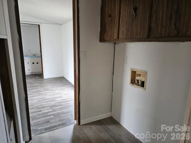 an empty room with wooden floor and cabinet
