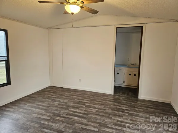 a view of a room with wooden floor and white walls