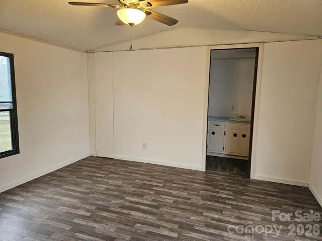 a view of a room with wooden floor and white walls