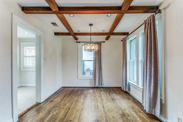 a view of hallway with a large window and wooden floor
