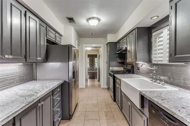 a kitchen with stainless steel appliances granite countertop a sink stove and refrigerator