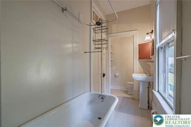 an empty room with windows and fireplace