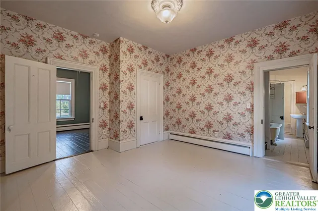 a view of a hallway with wooden floor and a cabinet