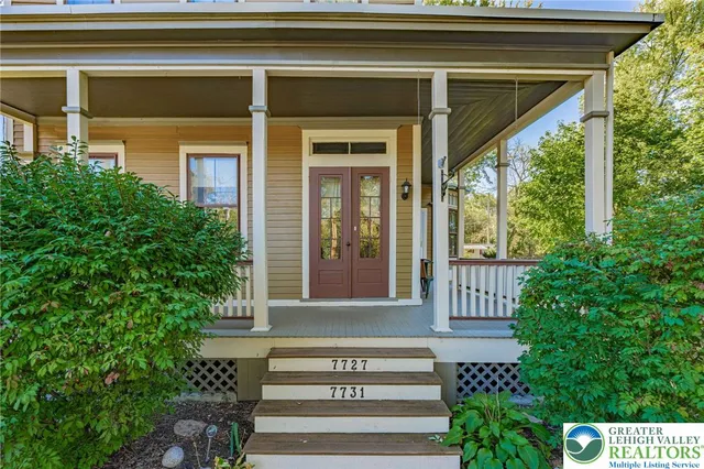 a view of a porch with a floor to ceiling window and tree