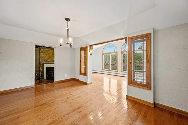a view of empty room with wooden floor and fireplace