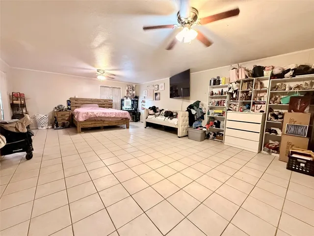 a spacious bedroom with a bed and a flat screen tv