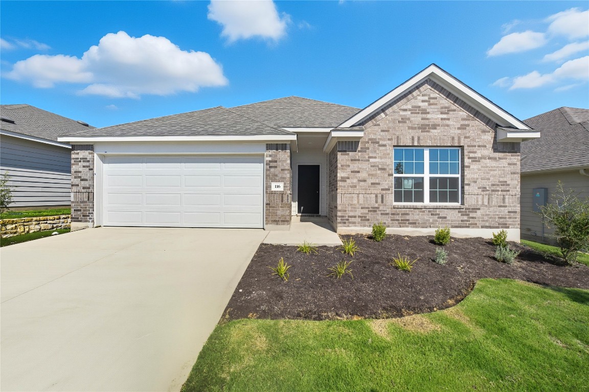 Single story home with driveway, an attached garage, brick siding, a front yard, and roof with shingles