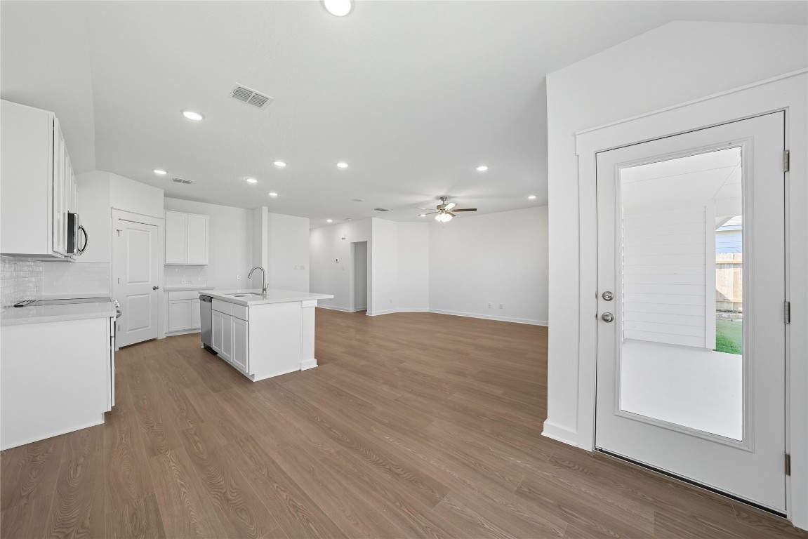 116 Crow Vly Drive Jarrell, TX 76537 - Photo 14 of 14 Kitchen featuring a kitchen island with sink, white cabinets, open floor plan, light wood finished floors, and recessed lighting