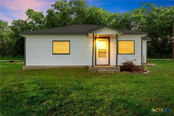 a view of a house with a backyard