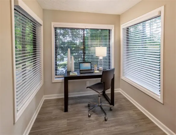 a view of a workspace with furniture and a window
