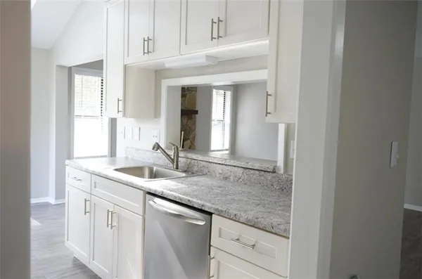 a kitchen with granite countertop a sink and cabinets
