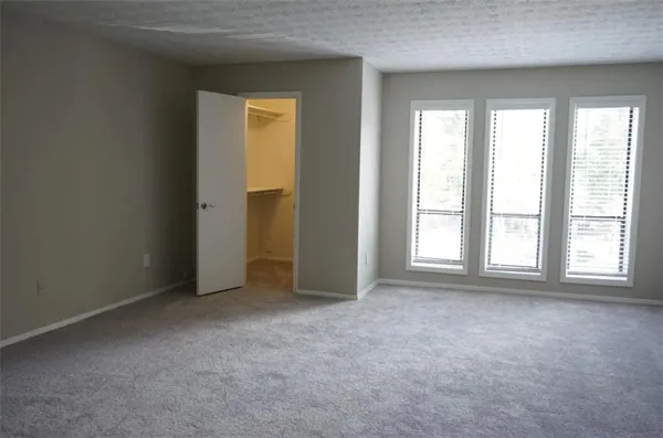 an empty room with windows and closet