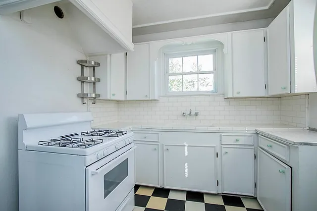 a kitchen with white cabinets and white appliances