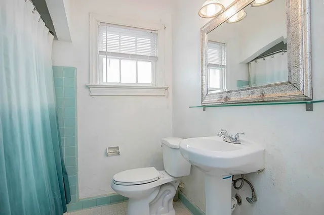 a bathroom with a sink toilet and a mirror