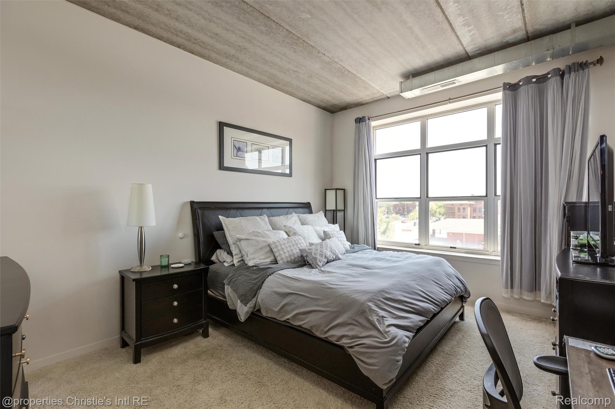 66 Winder Street, Unit 332 Detroit, MI 48201 - Photo 13 of 30 Bedroom with light colored carpet and baseboards