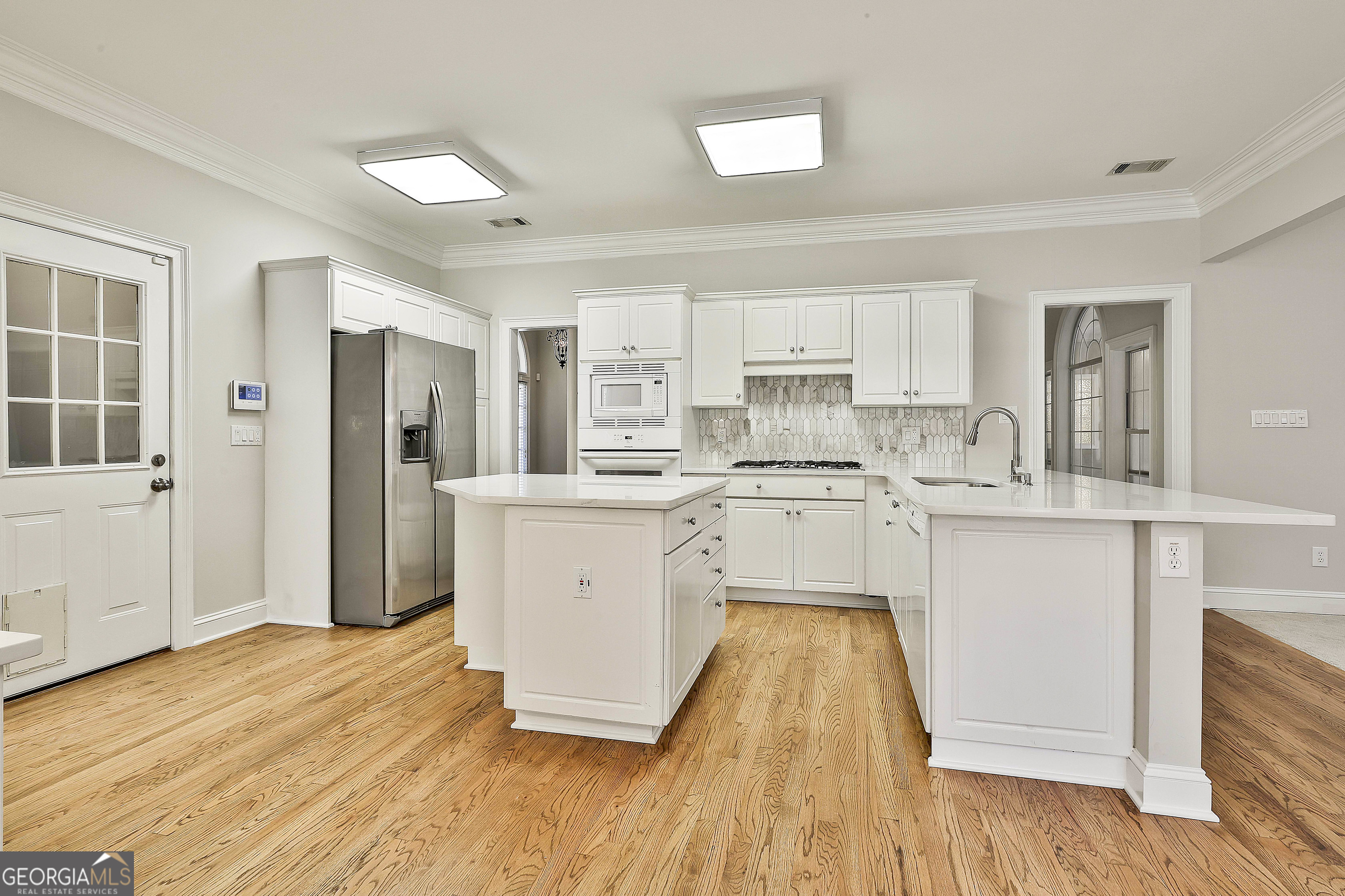 365 Pendleton Trail Tyrone, GA 30290 - Photo 24 of 55 a kitchen with white cabinets and wooden floor