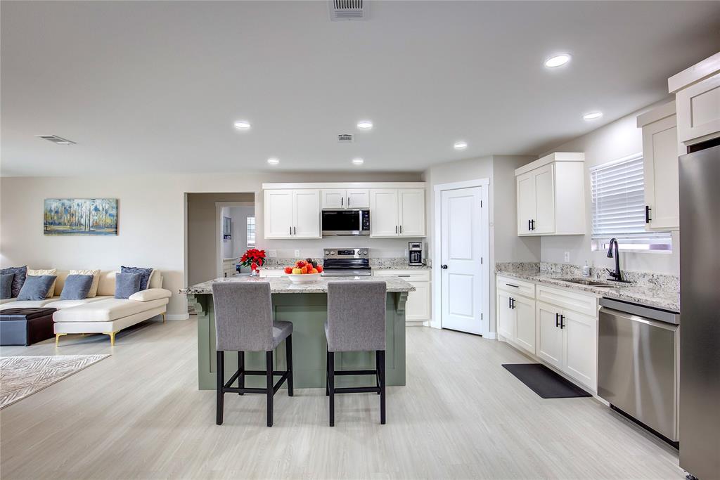 521 Private Road Brookston, TX 75421 - Photo 6 of 26 a kitchen with white cabinets and stainless steel appliances