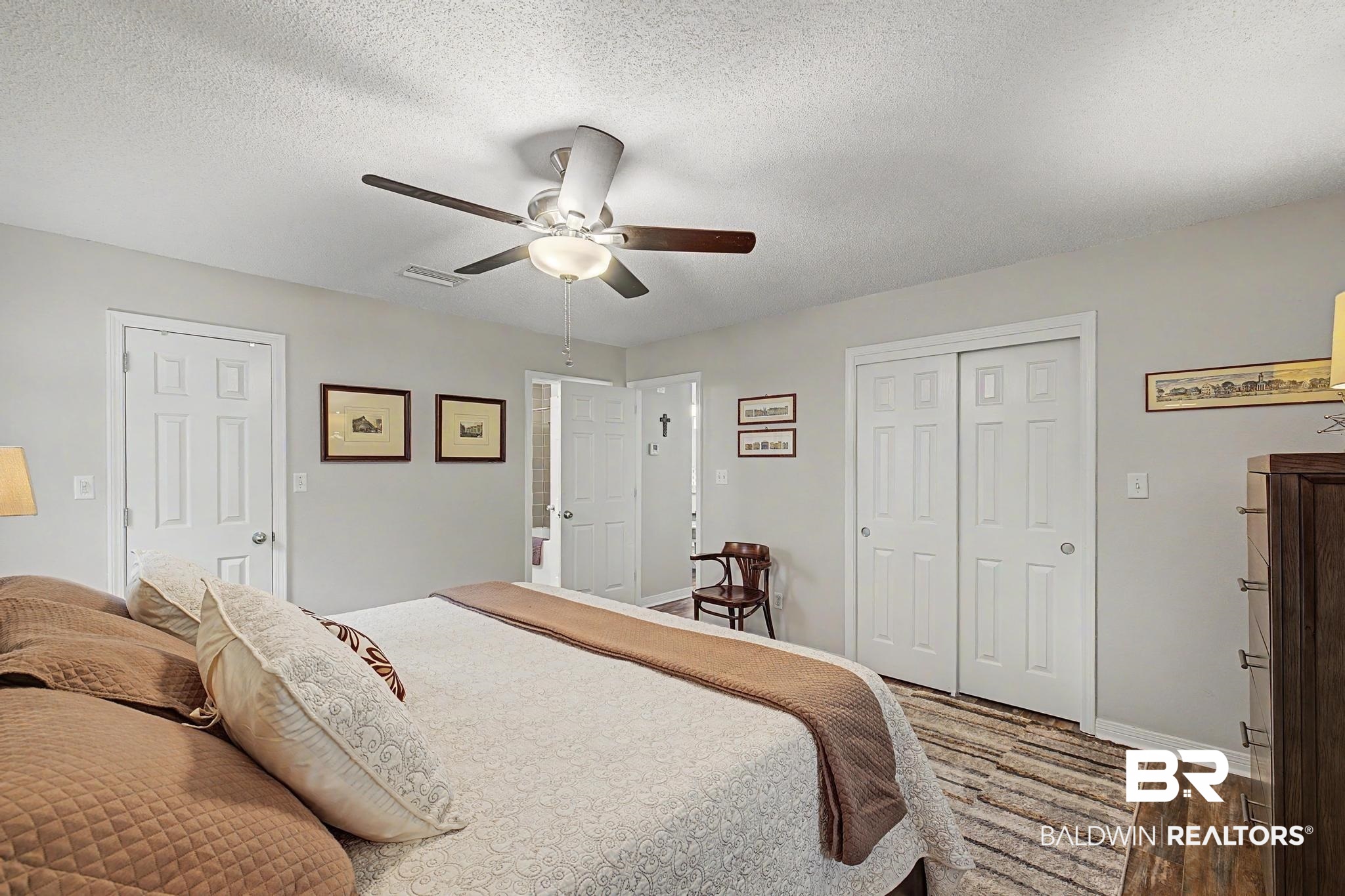 2808 Pine Ridge Drive Lillian, AL 36549 - Photo 18 of 47 Bedroom featuring a ceiling fan with integrated lighting, wood-finish flooring, and white paneled doors