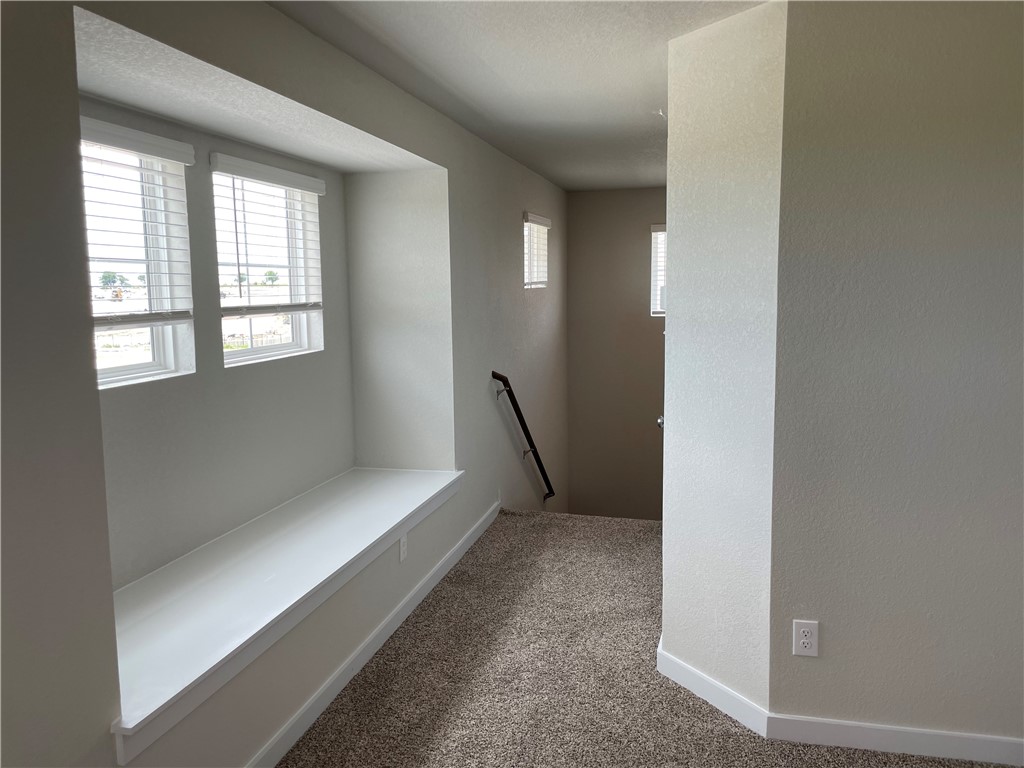 609 Paddock Lane Georgetown, TX 78626 - Photo 36 of 40 An upper landing features soft carpeting and a built-in window bench near the staircase.