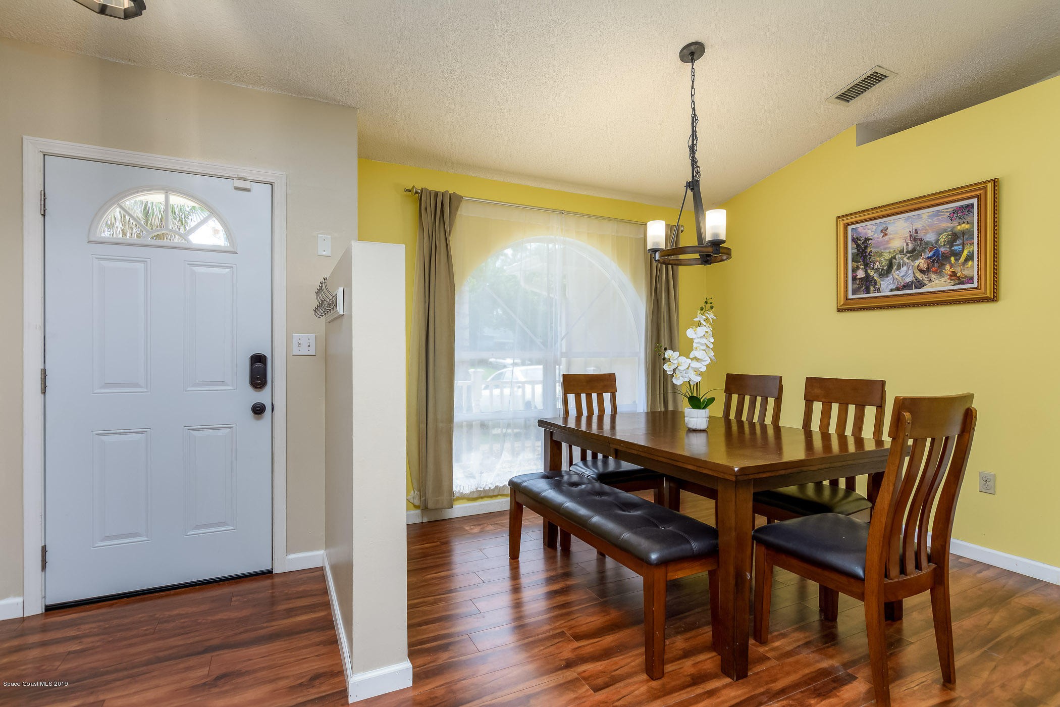 7010 Cairo Road Cocoa, FL 32927 - Photo 4 of 22 a dining room with furniture a chandelier and wooden floor