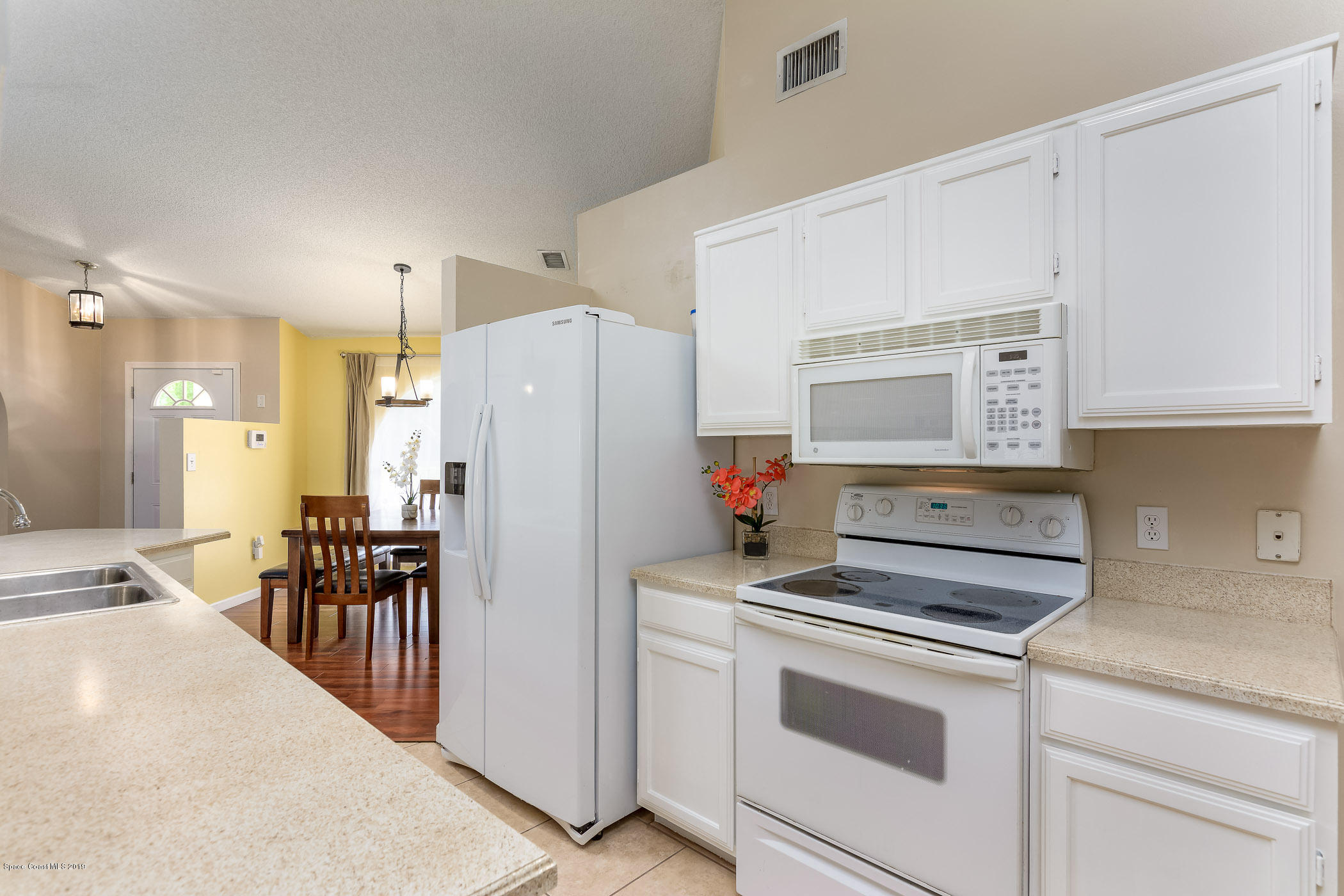 7010 Cairo Road Cocoa, FL 32927 - Photo 7 of 22 a kitchen with a refrigerator and white cabinets
