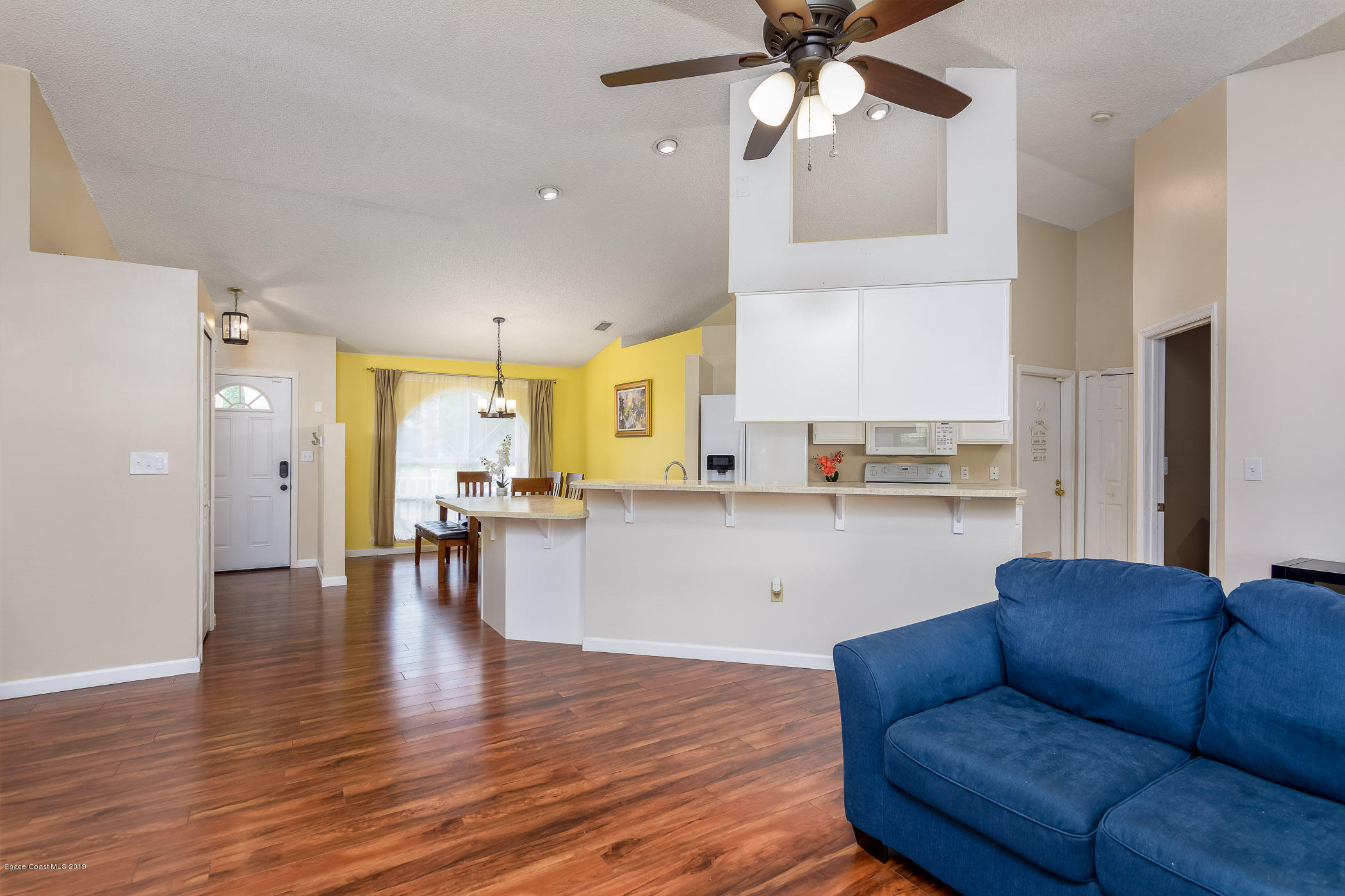 7010 Cairo Road Cocoa, FL 32927 - Photo 9 of 22 a living room with stainless steel appliances kitchen island granite countertop furniture and a wooden floor
