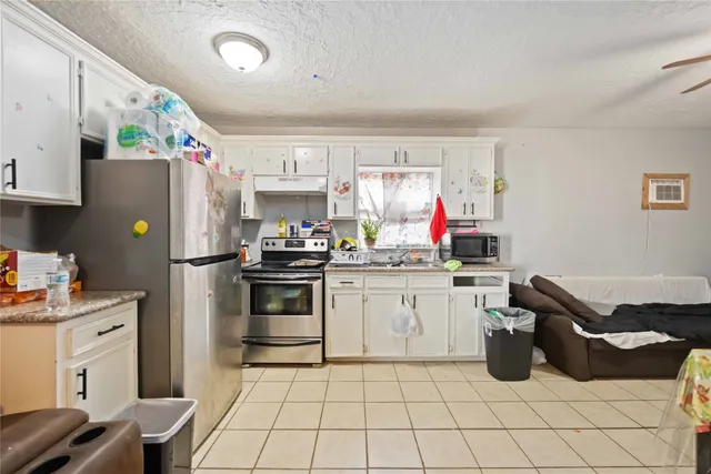 a kitchen with stainless steel appliances a stove top oven a sink dishwasher and a refrigerator with the cabinets