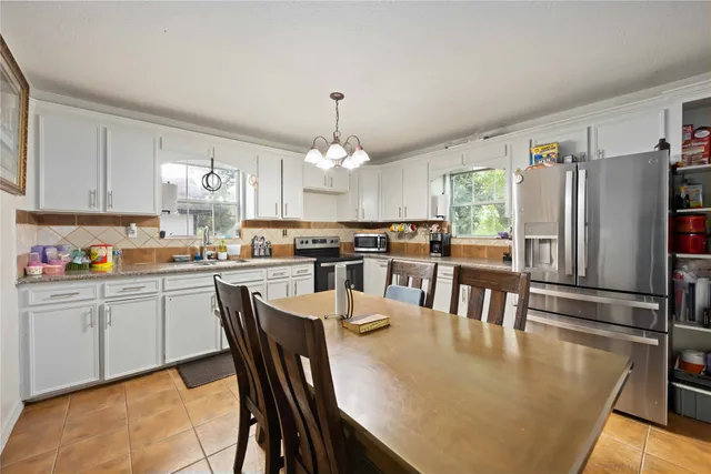 a kitchen with stainless steel appliances granite countertop a sink a stove and cabinets