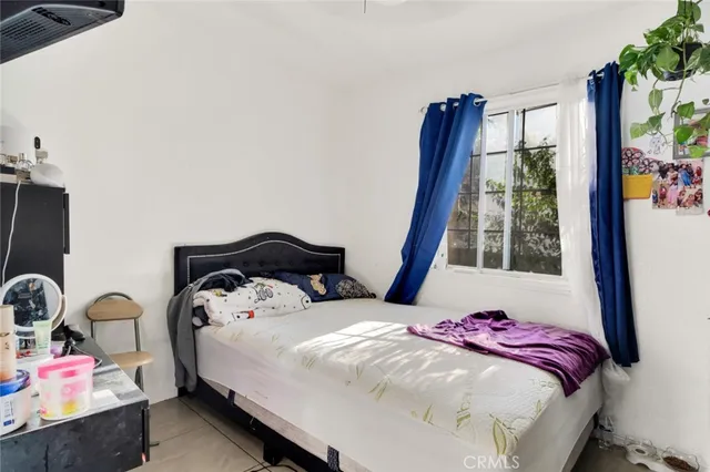 a bedroom with a bed and large windows