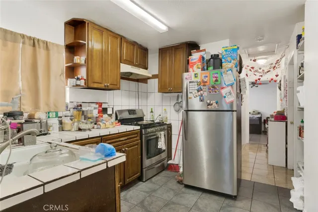 a kitchen with stainless steel appliances granite countertop a refrigerator and a sink