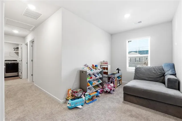 a living room with furniture and a gym machine