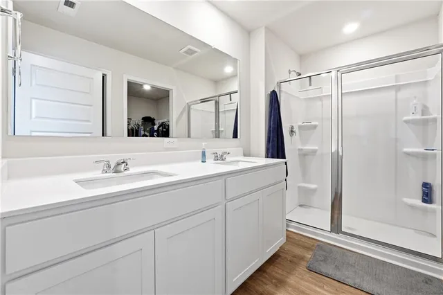 a bathroom with a double vanity sink mirror and shower