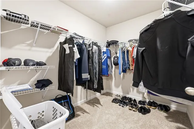 a view of walk in closet with clothes and shoes
