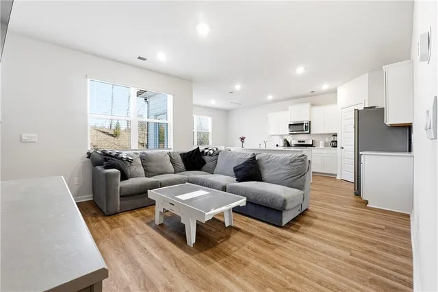 a living room with furniture and a wooden floor