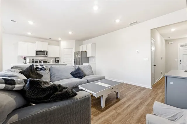 a living room with furniture and a wooden floor