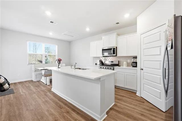 a kitchen with appliances a sink and cabinets