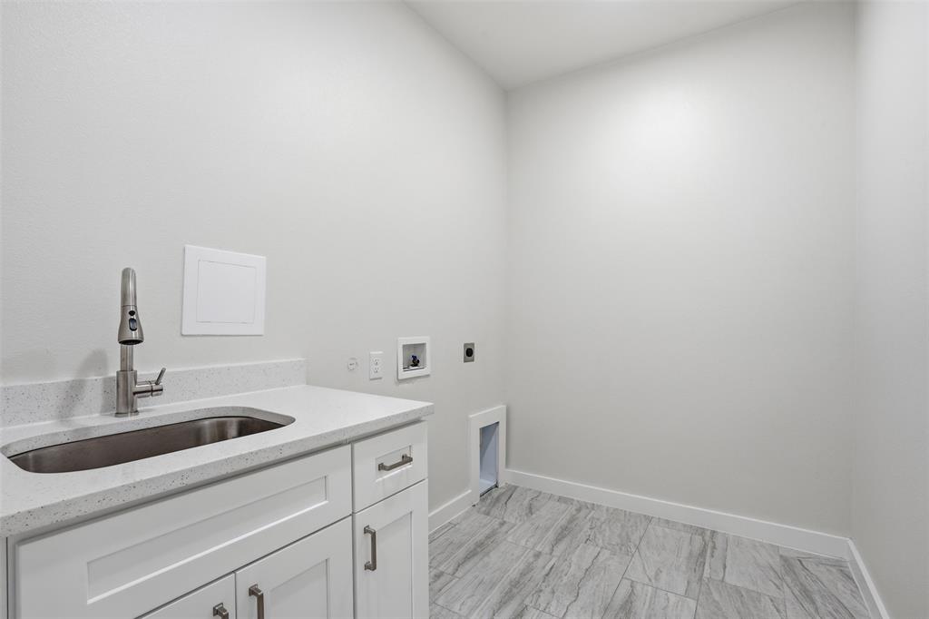 532 Highview Court Godley, TX 76044 - Photo 12 of 39 Utility room featuring a built-in sink with a pull-down faucet, white cabinetry with silver-tone hardware, and a light-colored countertop