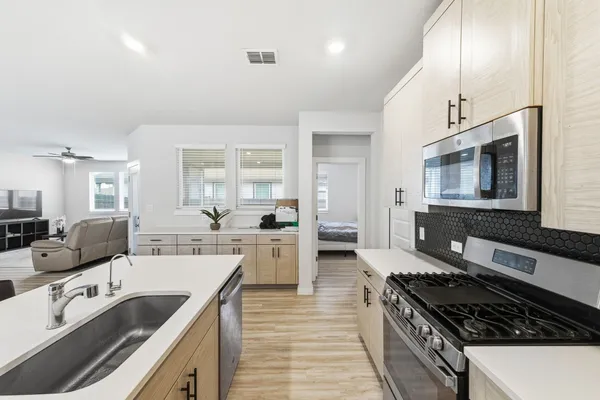 a kitchen with sink stove and microwave