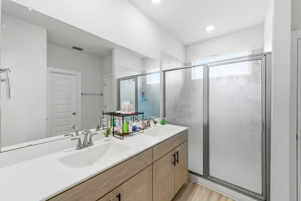 a bathroom with double vanity sink and a mirror