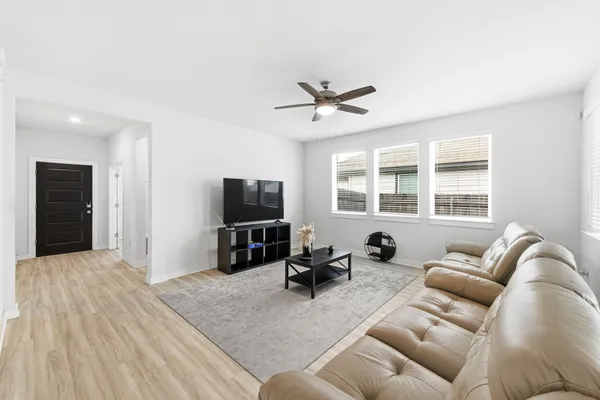 a living room with furniture a window and a flat screen tv
