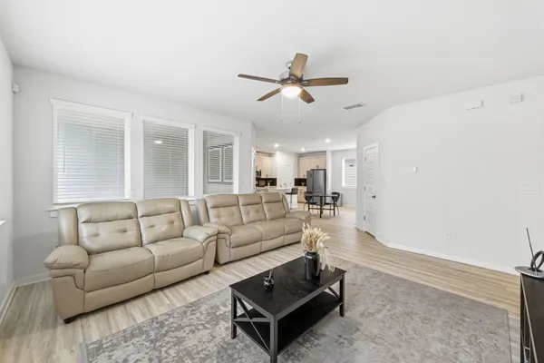 a living room with furniture and a ceiling fan