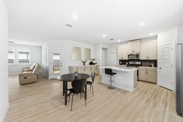 a kitchen with white cabinets and stainless steel appliances