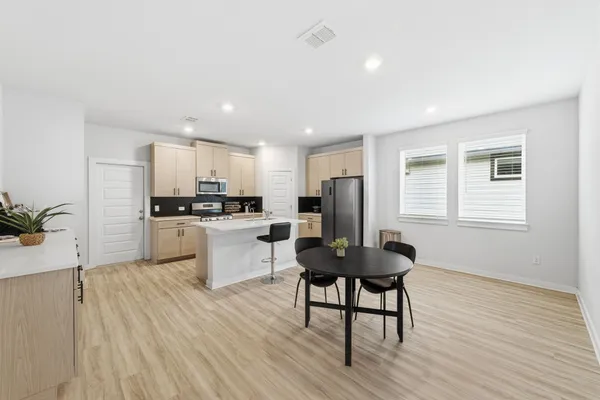 a kitchen with white cabinets and stainless steel appliances