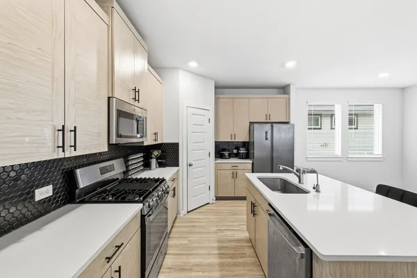a kitchen with stainless steel appliances granite countertop a sink stove and refrigerator