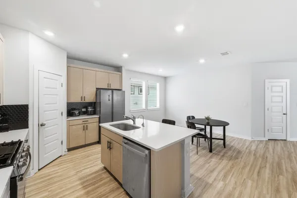 a kitchen with a sink a counter top space stainless steel appliances and cabinets