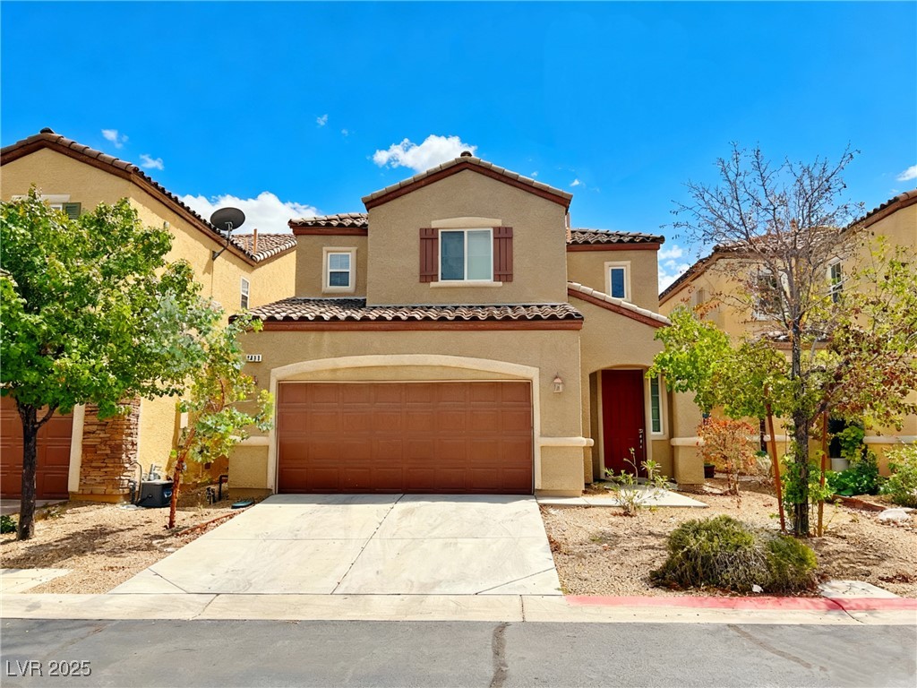 Mediterranean / spanish house with stucco siding, a tile roof, concrete driveway, and an attached garage