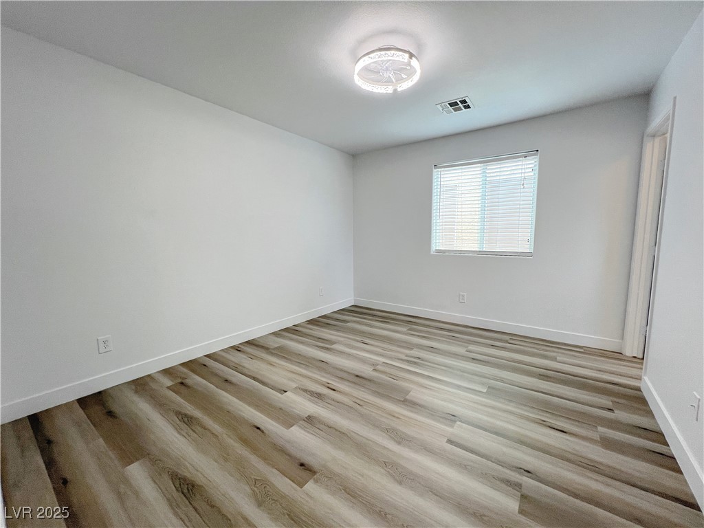 8821 Steaming Thunder Court Las Vegas, NV 89148 - Photo 14 of 31 Unfurnished bedroom with light wood-type flooring and baseboards