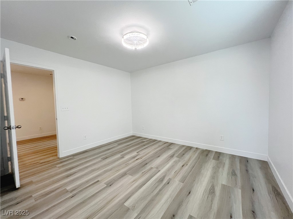 8821 Steaming Thunder Court Las Vegas, NV 89148 - Photo 15 of 31 Empty room featuring light wood finished floors and baseboards
