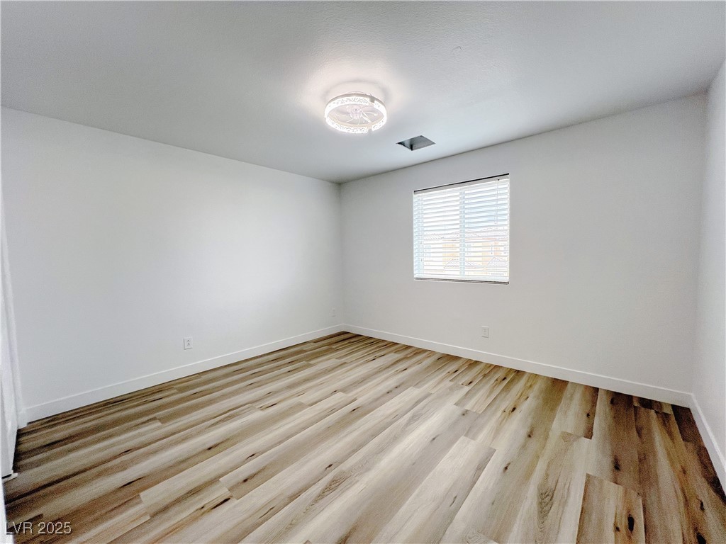 8821 Steaming Thunder Court Las Vegas, NV 89148 - Photo 19 of 31 Spare room featuring light wood finished floors and baseboards