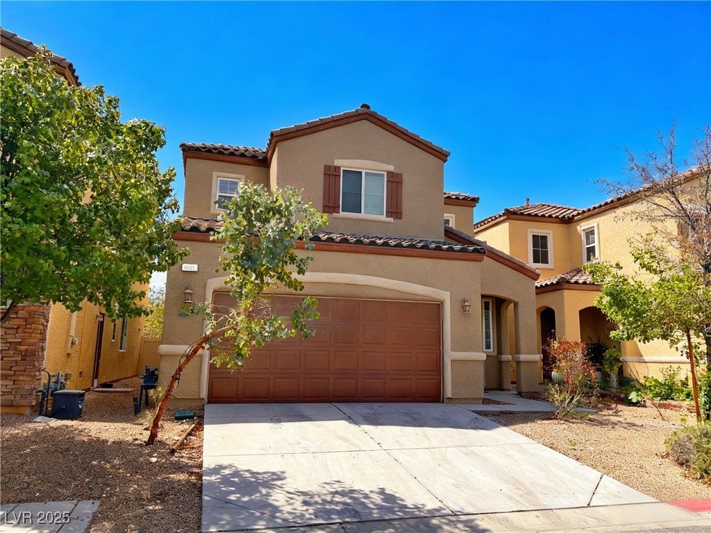 8821 Steaming Thunder Court Las Vegas, NV 89148 - Photo 2 of 31 Mediterranean / spanish house with stucco siding, a tile roof, driveway, and an attached garage